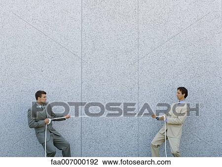 Two businessmen playing tug-of-war View Large Photo Image Stock Image - Two businessmen playing tug-of-war. Fotosearch