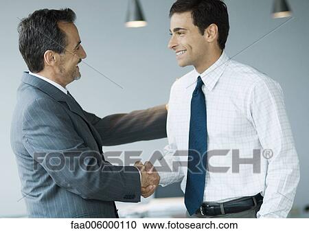 Stock Image - Two businessmen shaking hands. Fotosearch