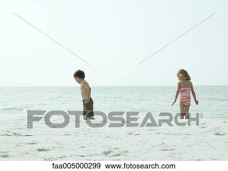Two children standing in water View Large Photo Image Stock Photo - Two children standing in water. Fotosearch