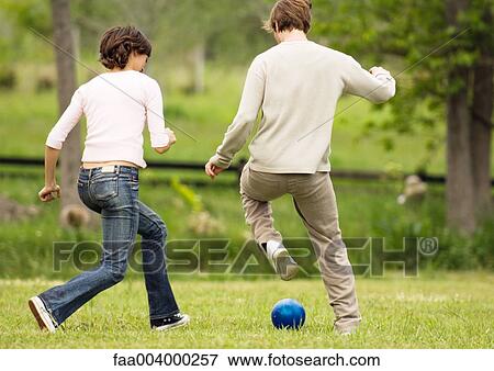 Two friends running after ball View Large Photo Image Stock Photo - Two friends running after ball. Fotosearch
