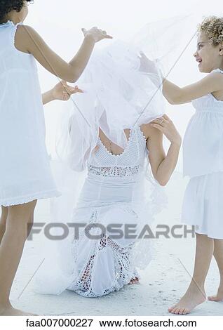 Two girls helping bride fix veil View Large Photo Image Stock Photo - Two girls helping bride fix veil. Fotosearch