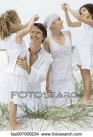 Two little girls holding hands over heads of bride and groom View Large Photo Image Picture - Two little girls holding hands over heads of bride and groom. Fotosearch