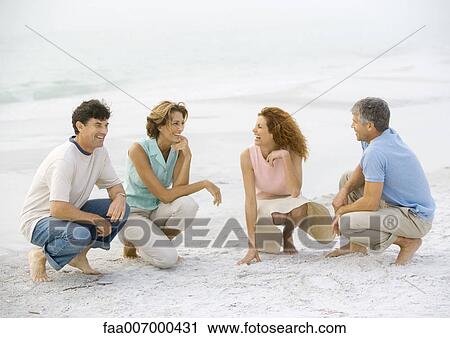Two mature couples crouching on beach View Large Photo Image Stock Image - Two mature couples crouching on beach. Fotosearch