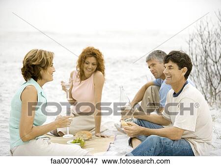 Two mature couples having picnic on beach View Large Photo Image Stock Photo - Two mature couples having picnic on beach. Fotosearch