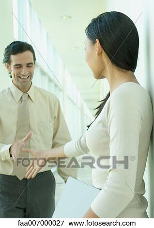 Two office workers shaking hands in hallway View Large Photo Image Stock Photo - Two office workers shaking hands in hallway. Fotosearch
