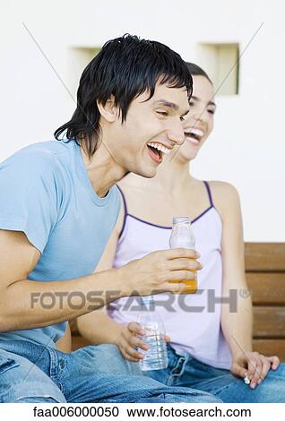 Two young adult friends with bottles laughing View Large Photo Image Stock Image - Two young adult friends with bottles laughing. Fotosearch