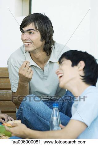 Two young adult friends with refreshments, laughing View Large Photo Image Stock Image - Two young adult friends with refreshments, laughing. Fotosearch