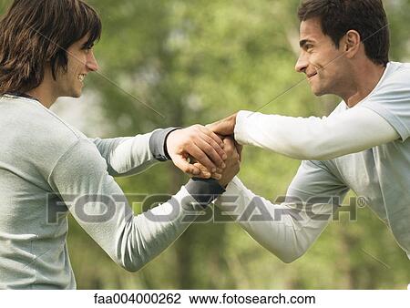 Two young male friends with hands clasped View Large Photo Image Stock Image - Two young male friends with hands clasped. Fotosearch