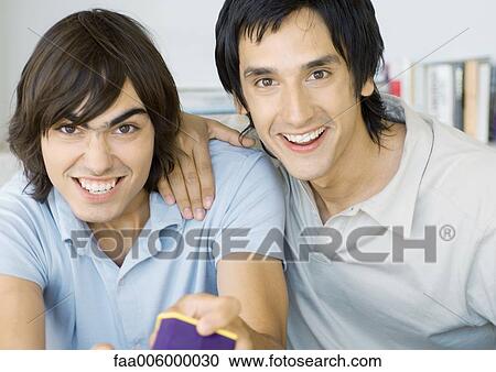 Two young men playing video games View Large Photo Image Stock Image - Two young men playing video games. Fotosearch