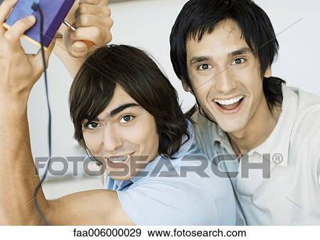 Two young men playing video games View Large Photo Image Stock Photo - Two young men playing video games. Fotosearch