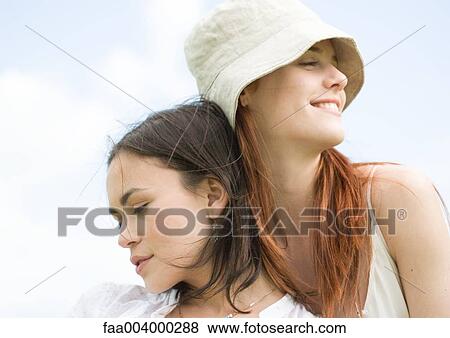 Two young women, leaning on each other with eyes closed View Large Photo Image Stock Photo - Two young women, leaning on each other with eyes closed. Fotosearch