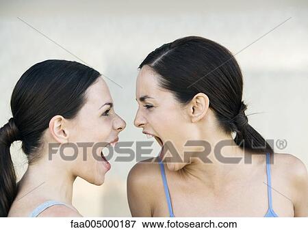 Two young women screaming at each other View Large Photo Image Stock Photo - Two young women screaming at each other. Fotosearch