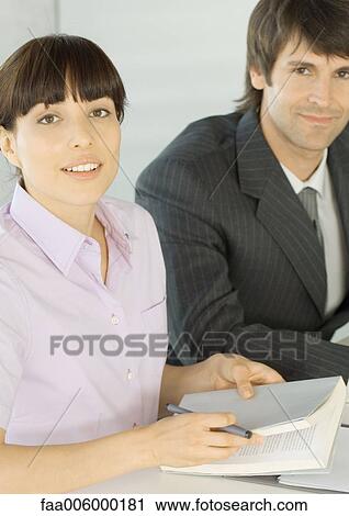 Stock Image - Woman and businessman, looking at camera. Fotosearch