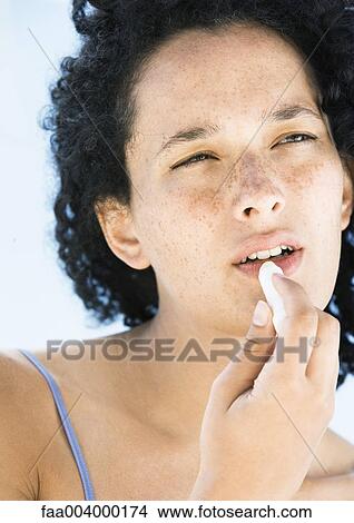Woman applying lip balm View Large Photo Image Picture - Woman applying lip balm. Fotosearch
