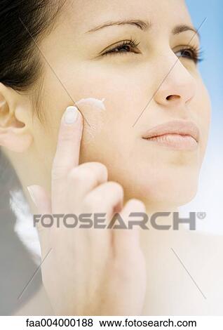 Woman applying moisturizer to cheek View Large Photo Image Stock Photo - Woman applying moisturizer to cheek. Fotosearch