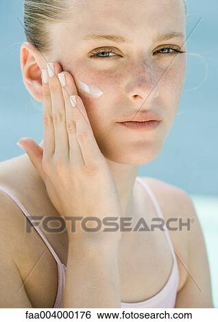 Stock Photograph - Woman applying sunscreen . Fotosearch