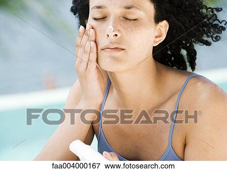 Woman applying sunscreen to face View Large Photo Image Stock Photo - Woman applying sunscreen to face. Fotosearch