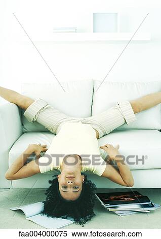 Woman hanging upside down off edge of sofa View Large Photo Image Stock Photography - Woman hanging upside down off edge of sofa. Fotosearch