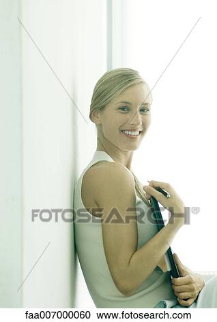 Woman holding file in front of chest, smiling at camera View Large Photo Image Stock Image - Woman holding file in front of chest, smiling at camera. Fotosearch