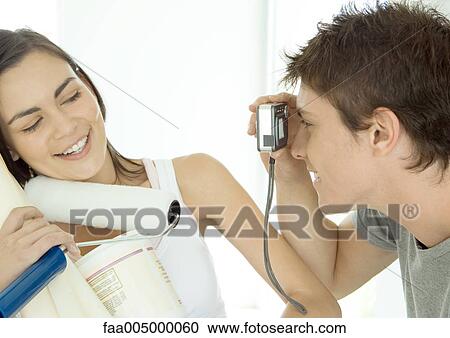 Woman holding painting supplies while man takes her photo View Large Photo Image Stock Image - Woman holding painting supplies while man takes her photo. Fotosearch