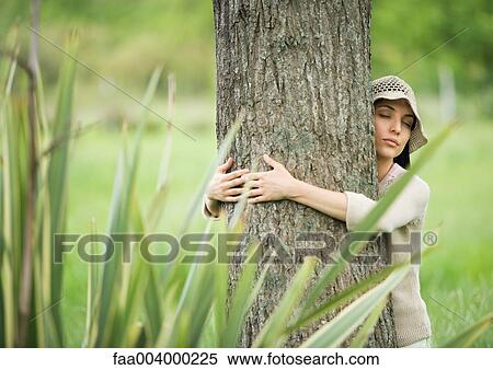 Woman hugging tree with eyes closed View Large Photo Image Stock Photography - Woman hugging tree with eyes closed. Fotosearch
