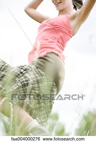 Woman in long grass, low angle view View Large Photo Image Stock Photograph - Woman in long grass, low angle view. Fotosearch