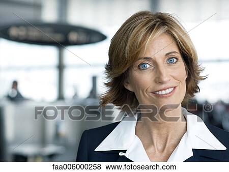 Woman in suit smiling in airport setting, portrait View Large Photo Image Stock Photo - Woman in suit smiling in airport setting, portrait. Fotosearch