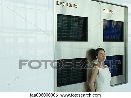 Woman leaning against arrival and departure boards with eyes closed View Large Photo Image Stock Photography - Woman leaning against arrival and departure boards with eyes closed. Fotosearch