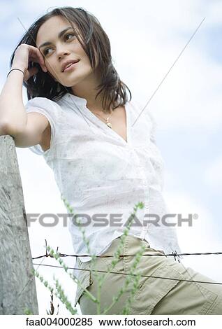 Woman leaning on fence post View Large Photo Image Stock Photography - Woman leaning on fence post. Fotosearch