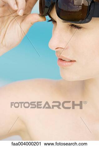 Woman lifting sunglasses View Large Photo Image Stock Image - Woman lifting sunglasses. Fotosearch