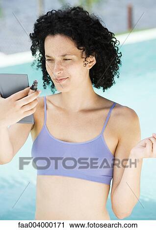 Woman looking at self in mirror, pool in background View Large Photo Image Stock Image - Woman looking at self in mirror, pool in background. Fotosearch
