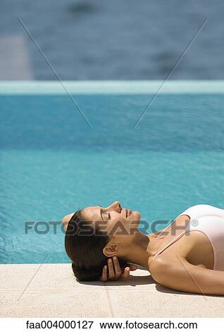 Woman lying on ground near edge of pool View Large Photo Image Stock Photo - Woman lying on ground near edge of pool . Fotosearch