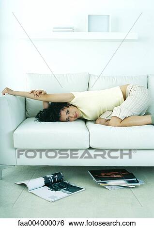 Stock Photograph - Woman lying on sofa. Fotosearch