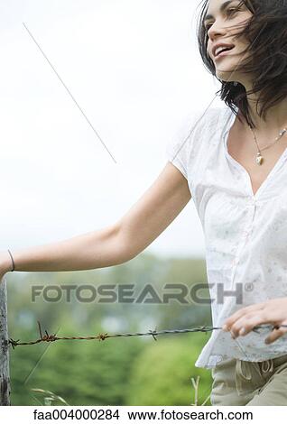 Woman next to fence View Large Photo Image Picture - Woman next to fence. Fotosearch