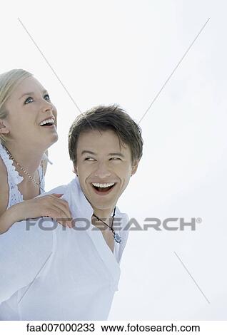 Woman on man's back, both laughing View Large Photo Image Stock Image - Woman on man's back, both laughing. Fotosearch