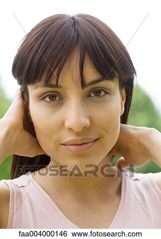 Stock Photograph - Woman pushing hair back. Fotosearch