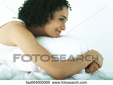 Woman resting head on pillow, smiling View Large Photo Image Stock Photo - Woman resting head on pillow, smiling. Fotosearch