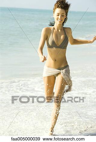 Woman running in surf at beach View Large Photo Image Stock Photo - Woman running in surf at beach. Fotosearch