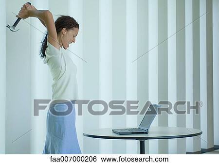 Woman shouting and swinging hammer at laptop View Large Photo Image Stock Photograph - Woman shouting and swinging hammer at laptop. Fotosearch