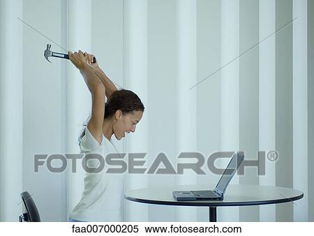 Woman shouting and swinging hammer at laptop View Large Photo Image Stock Photography - Woman shouting and swinging hammer at laptop. Fotosearch