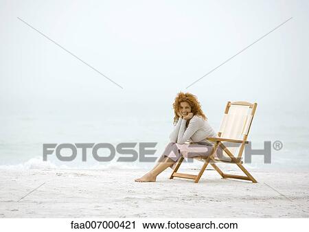Woman sitting in beach chair View Large Photo Image Stock Image - Woman sitting in beach chair. Fotosearch