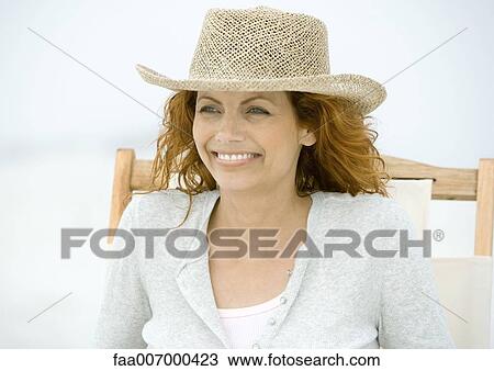 Woman sitting in beach chair, wearing sun hat View Large Photo Image Stock Image - Woman sitting in beach chair, wearing sun hat. Fotosearch