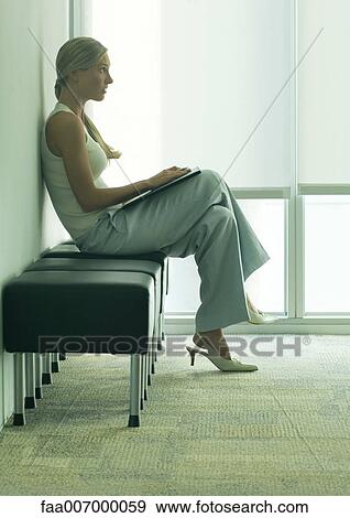 Woman sitting in waiting room View Large Photo Image Stock Photo - Woman sitting in waiting room. Fotosearch