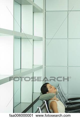Woman sleeping in airport lounge, using neck cushion View Large Photo Image Stock Image - Woman sleeping in airport lounge, using neck cushion . Fotosearch