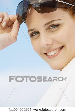 Woman smiling and holding up sunglasses View Large Photo Image Picture - Woman smiling and holding up sunglasses. Fotosearch