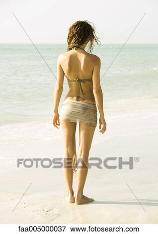 Woman standing on beach, rear view View Large Photo Image Stock Photo - Woman standing on beach, rear view. Fotosearch