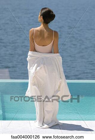 Woman standing overlooking water, bathrobe off shoulders View Large Photo Image Stock Photograph - Woman standing overlooking water, bathrobe off shoulders. Fotosearch