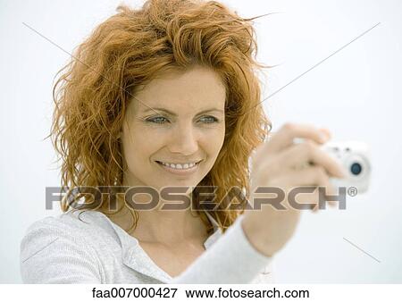 Stock Photo - Woman taking photo with camera. Fotosearch