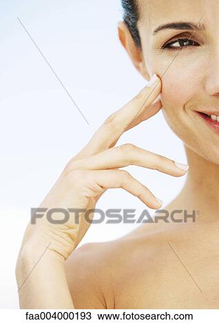 Woman touching cheek and smiling View Large Photo Image Stock Image - Woman touching cheek and smiling. Fotosearch