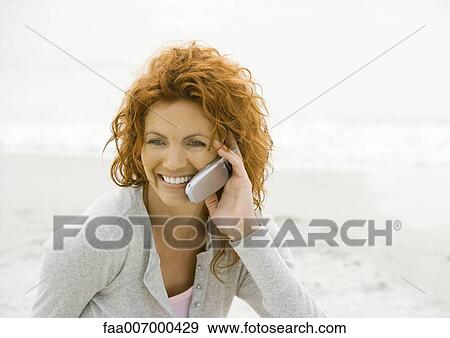 Woman using cell phone on beach View Large Photo Image Stock Photo - Woman using cell phone on beach. Fotosearch